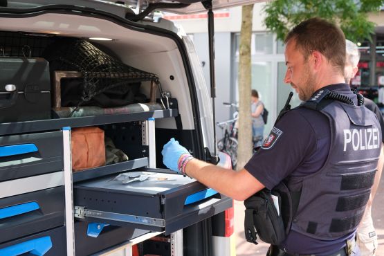 Ein Polizist führt einen Drogenvortest durch. Er trägt blaue Einmalhandschuhe
