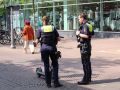 Eine Polizistin und ein Polizist kontrollieren einen E-Scooterfahrer in der Fußgängerzone. Die Person mit dem E-Scooter wird von der Polizistin verdeckt