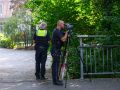 Ein Polizist führt eine Geschwindigkeitsmessung durch. Neben ihm steht mit dem Rücken zur Kamera ein weiterer Polizist